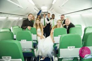 Hochzeitsfoto im Brautkleind mit dem Personal der Flugzeugs. Die Anreise im Flugzeug