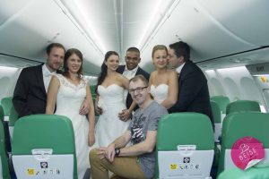 Hochzeitsfoto im Brautkleind mit dem Personal der Flugzeugs. Die Anreise im Flugzeug