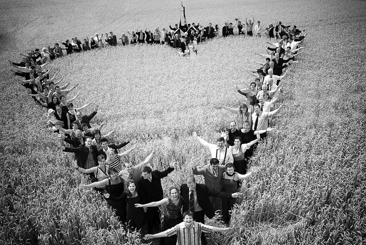Sehr ausgefallenes Hochzeits Gruppenfoto im Weizenfeld.